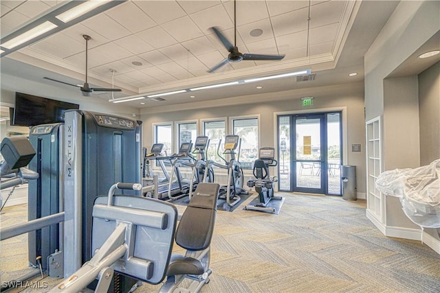 gym featuring light carpet, visible vents, a raised ceiling, ceiling fan, and ornamental molding