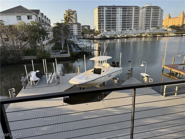 dock area featuring a water view, boat lift, and a city view