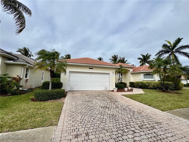 view of front of home with a garage, a tile roof, decorative driveway, stucco siding, and a front lawn