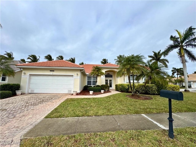 view of front of home with a tile roof, an attached garage, decorative driveway, a front yard, and stucco siding