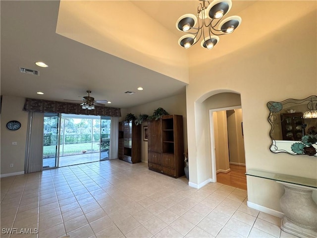 unfurnished room featuring arched walkways, recessed lighting, ceiling fan with notable chandelier, visible vents, and baseboards