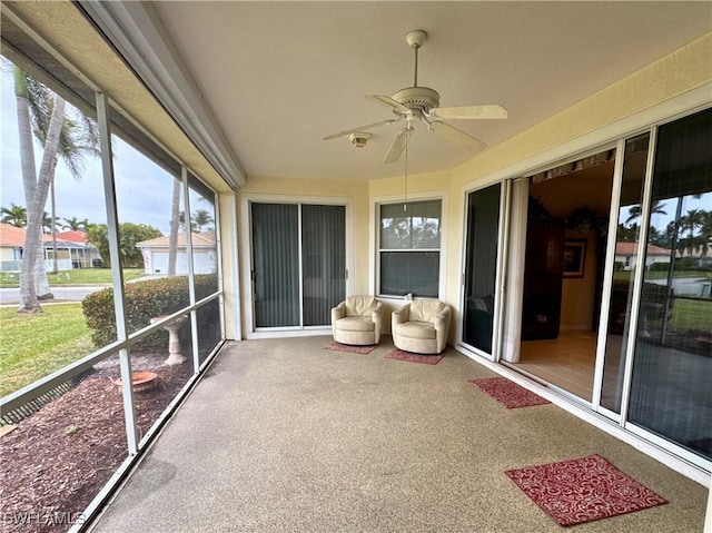 unfurnished sunroom with ceiling fan