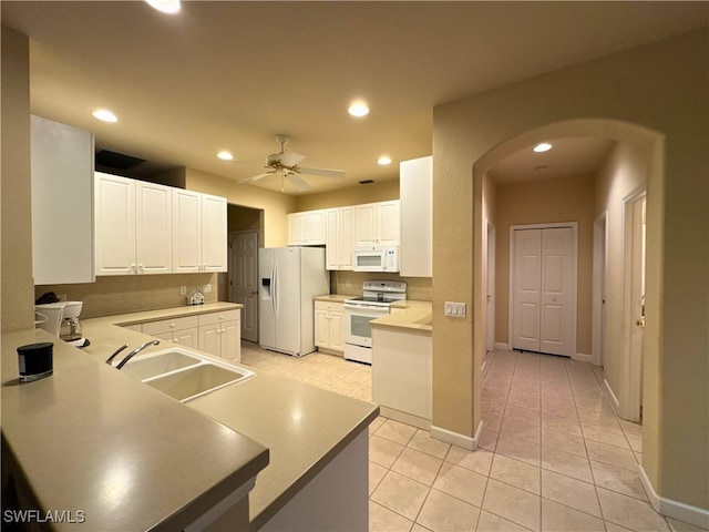 kitchen featuring white appliances, arched walkways, ceiling fan, a sink, and recessed lighting