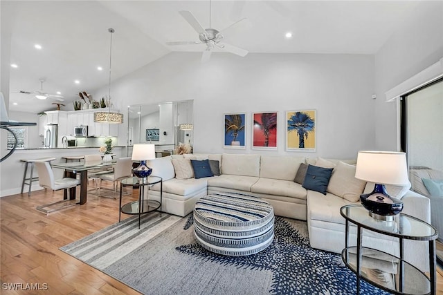 living room featuring high vaulted ceiling, recessed lighting, ceiling fan, and light wood finished floors