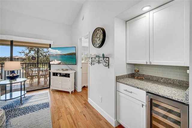 kitchen featuring tasteful backsplash, beverage cooler, a healthy amount of sunlight, and white cabinets