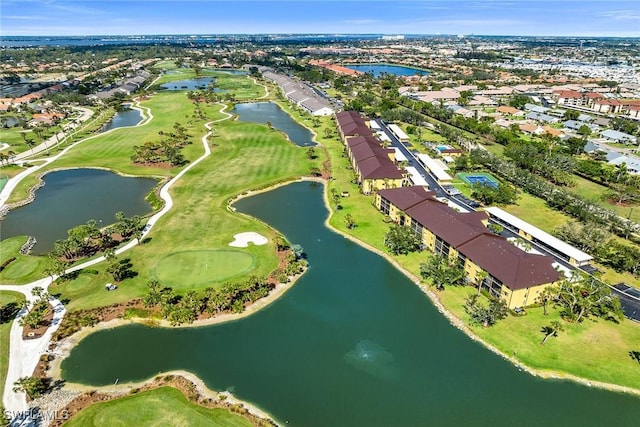 drone / aerial view featuring golf course view, a water view, and a residential view