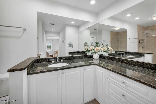 ensuite bathroom with ensuite bathroom, recessed lighting, a sink, a tile shower, and double vanity