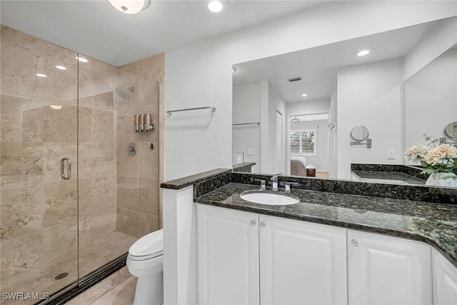 bathroom featuring toilet, ensuite bathroom, vanity, a shower stall, and recessed lighting