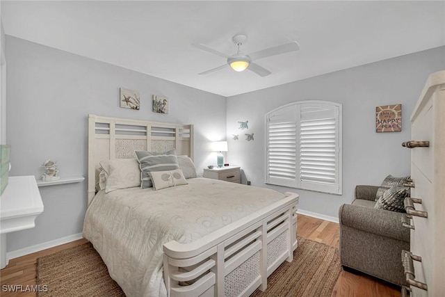 bedroom with ceiling fan, baseboards, and wood finished floors