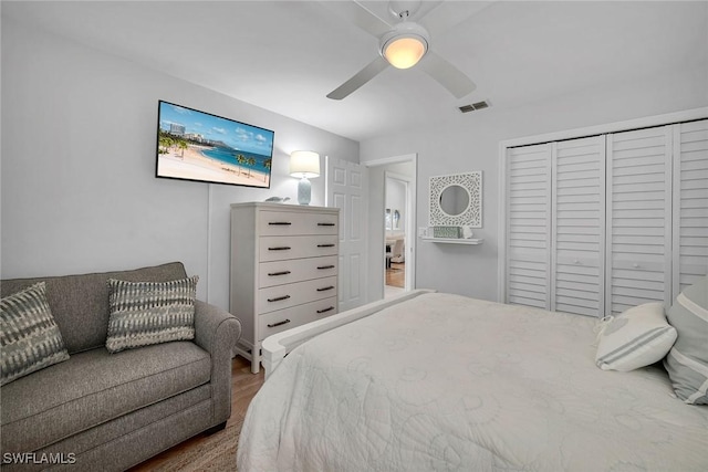 bedroom with ceiling fan, a closet, wood finished floors, and visible vents