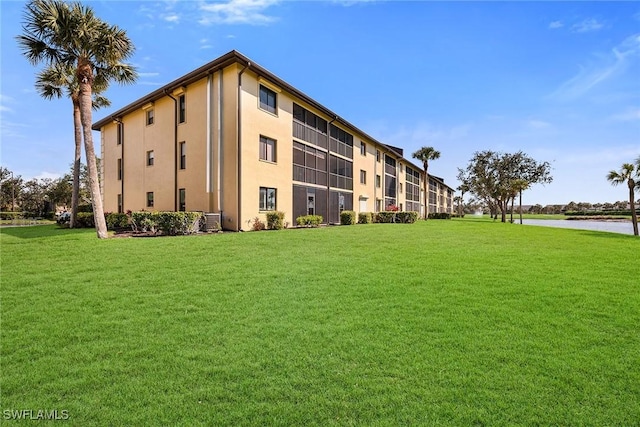 view of building exterior with a water view and central AC unit