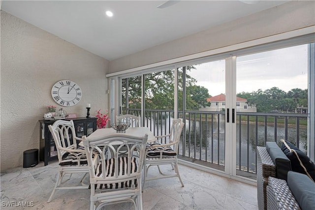 sunroom / solarium with a water view and vaulted ceiling