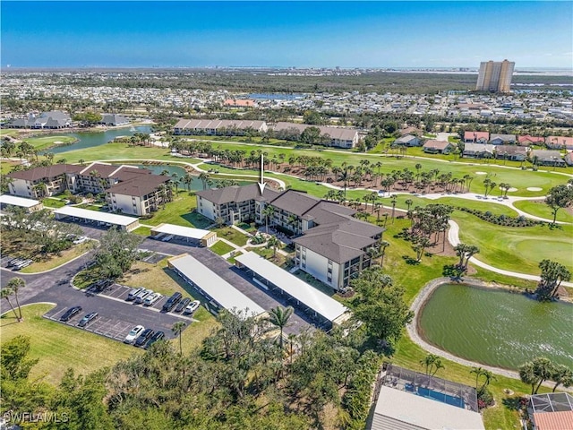 drone / aerial view featuring golf course view, a water view, and a residential view