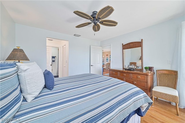 bedroom with a ceiling fan, visible vents, and light wood finished floors