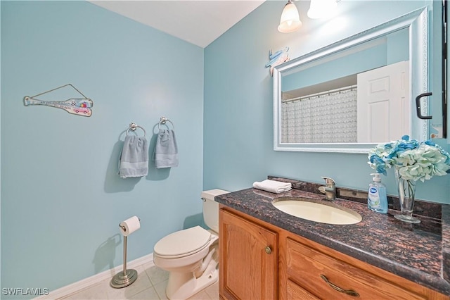 bathroom with baseboards, vanity, toilet, and tile patterned floors