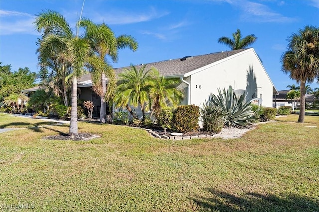 view of front of home featuring stucco siding and a front yard