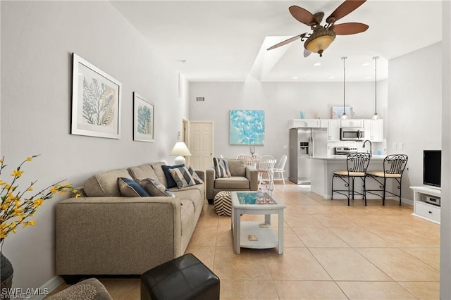 living area with light tile patterned floors, recessed lighting, a ceiling fan, and baseboards