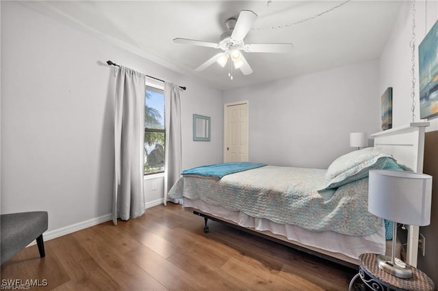 bedroom with wood finished floors, a ceiling fan, and baseboards