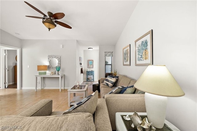 living room featuring ceiling fan, vaulted ceiling, tile patterned flooring, and baseboards