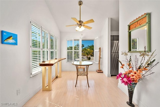 dining space featuring vaulted ceiling, ceiling fan, baseboards, and light wood-style floors