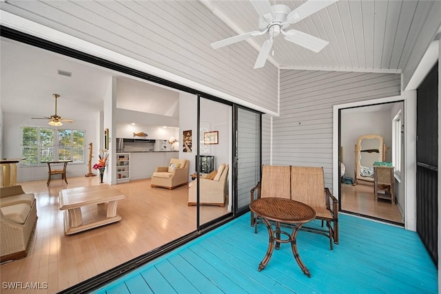 sitting room with vaulted ceiling, ceiling fan, wood finished floors, and visible vents