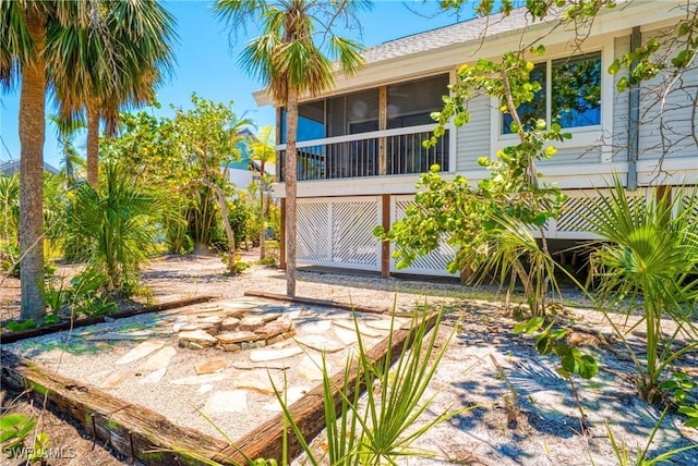 rear view of property featuring a sunroom