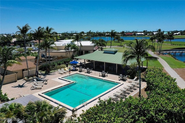 pool featuring a water view, fence, and a patio