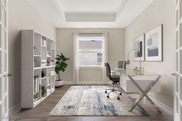 office featuring baseboards, a raised ceiling, and wood tiled floor