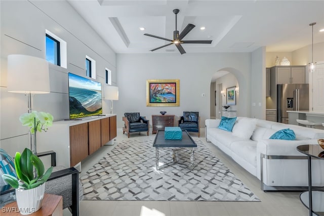 living room with arched walkways, recessed lighting, a towering ceiling, ceiling fan, and coffered ceiling