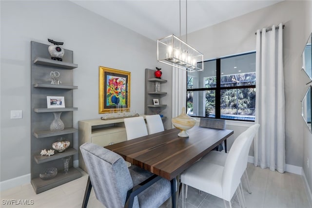 dining room featuring an inviting chandelier and baseboards