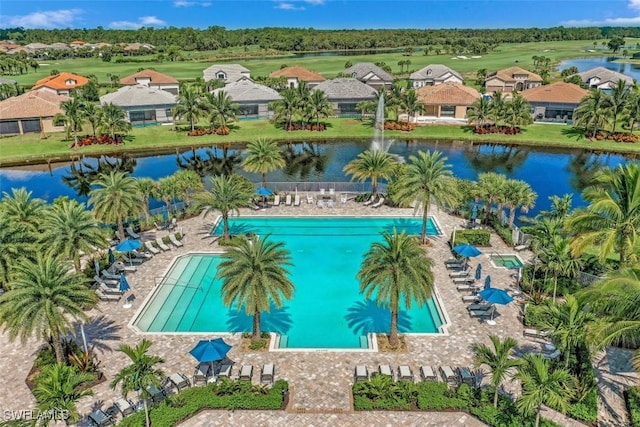 community pool with a water view and a residential view