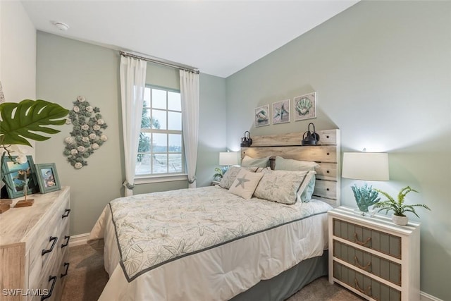 bedroom with baseboards and dark colored carpet