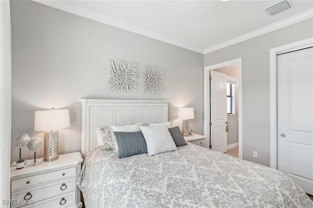 bedroom featuring a closet, visible vents, and crown molding