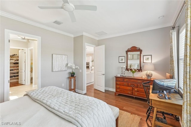 bedroom featuring baseboards, wood finished floors, visible vents, and crown molding