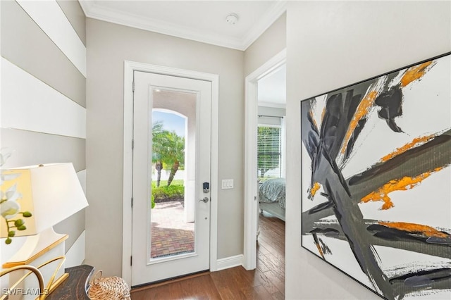 doorway featuring ornamental molding, wood finished floors, and baseboards