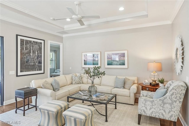 living area featuring crown molding, recessed lighting, a raised ceiling, light wood-style floors, and baseboards