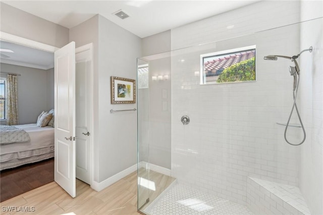 full bath featuring wood finished floors, visible vents, a tile shower, and ensuite bathroom