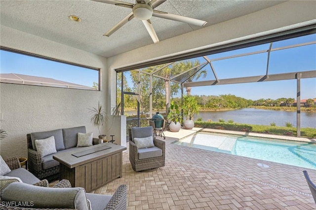 sunroom / solarium with a water view, ceiling fan, and a pool