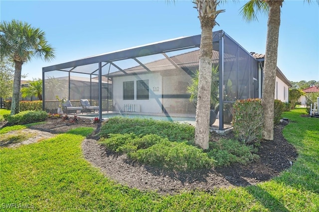 back of property featuring a lanai, an outdoor pool, and a yard