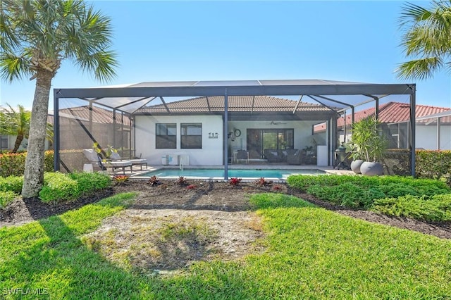 back of property with an outdoor pool, a ceiling fan, a patio, glass enclosure, and stucco siding