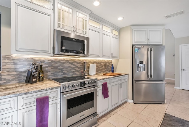 kitchen with visible vents, stainless steel appliances, white cabinets, glass insert cabinets, and tasteful backsplash