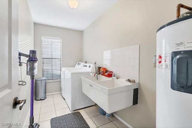 laundry area with light tile patterned floors, laundry area, a sink, electric water heater, and washing machine and dryer