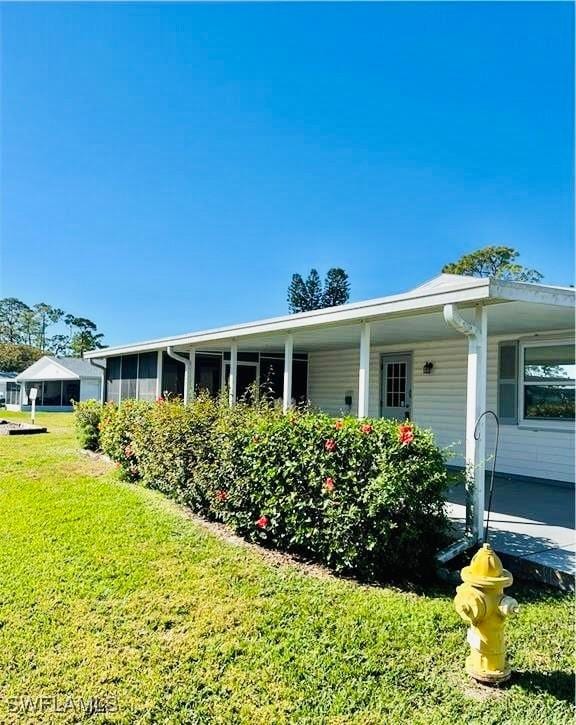 view of side of home with a yard