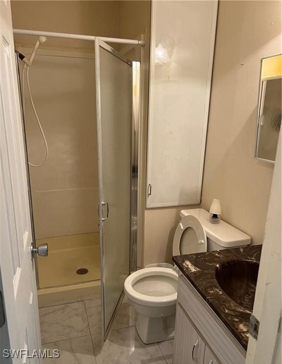 bathroom with marble finish floor, toilet, a shower stall, and vanity