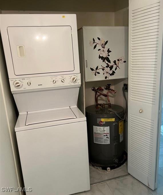 laundry area with stacked washer / drying machine, laundry area, and electric water heater