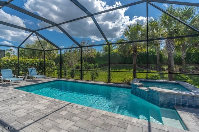 view of swimming pool featuring a patio, glass enclosure, and a pool with connected hot tub