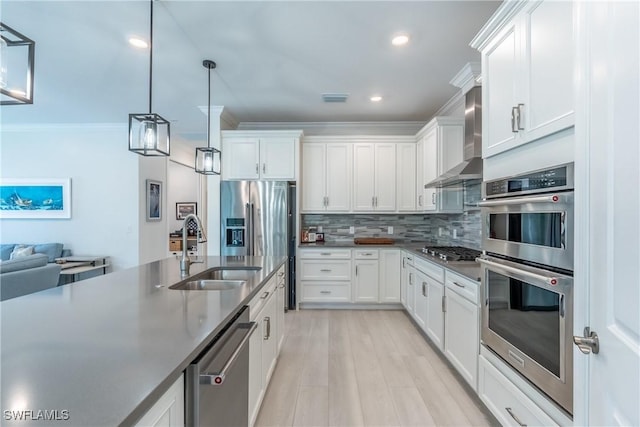 kitchen featuring decorative backsplash, dark countertops, wall chimney exhaust hood, stainless steel appliances, and a sink