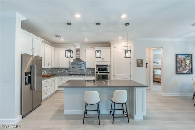 kitchen with appliances with stainless steel finishes, dark countertops, a sink, and wall chimney exhaust hood