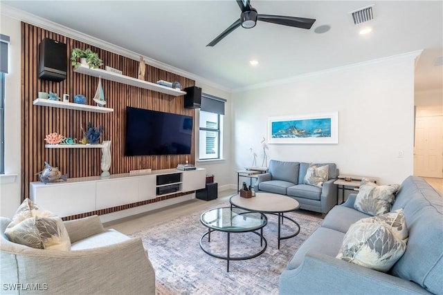 living area with ceiling fan, recessed lighting, wood finished floors, visible vents, and crown molding