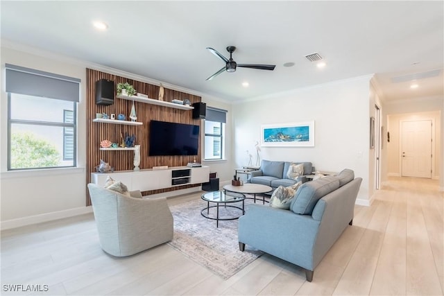 living room featuring ornamental molding, a healthy amount of sunlight, visible vents, and ceiling fan